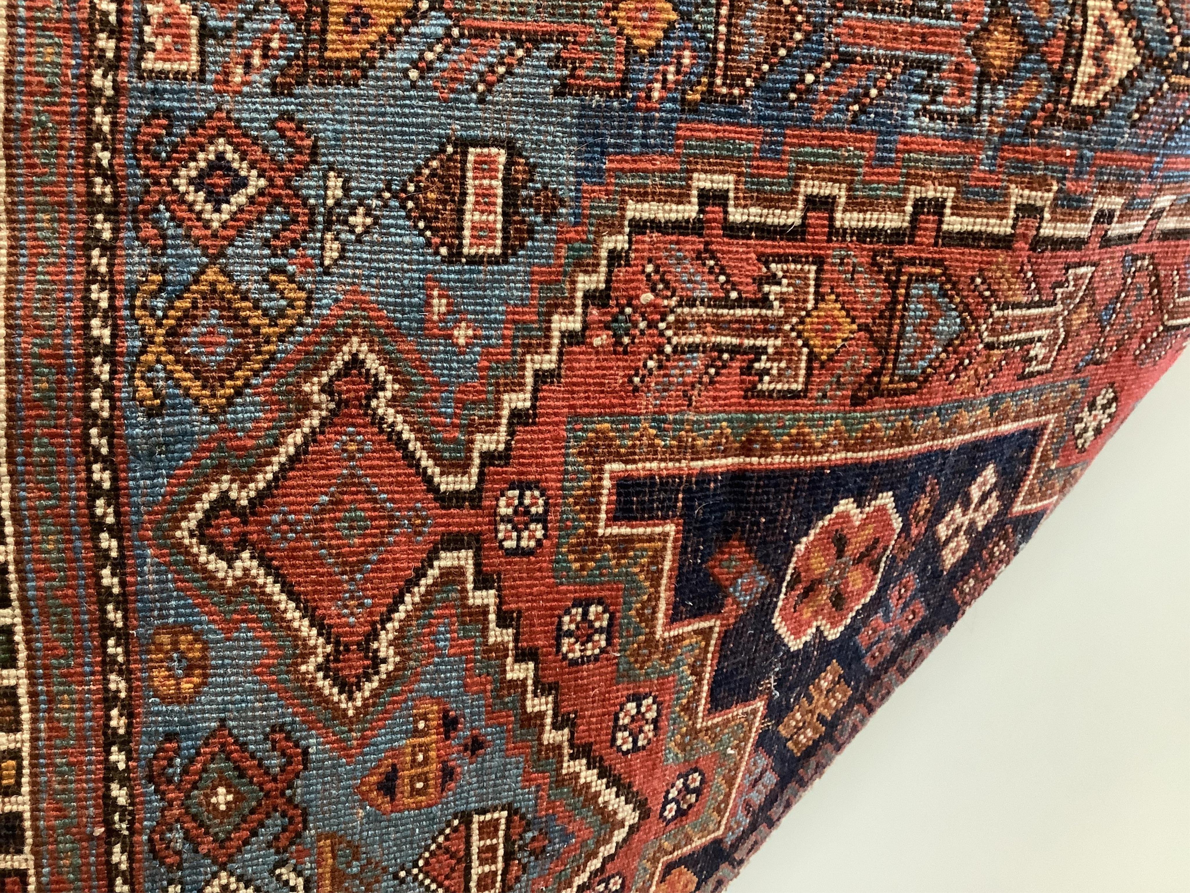 A Caucasian red ground rug, 150 x 118cm. Condition - worn in centre and a little faded, further wear around the edges